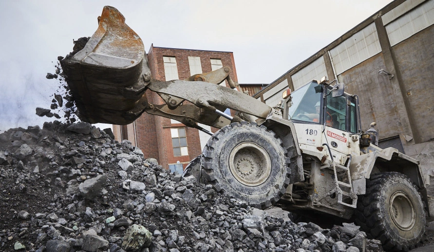 Schaufelbagger beim Verfahren von Metallschlacken und Ofenausbruch